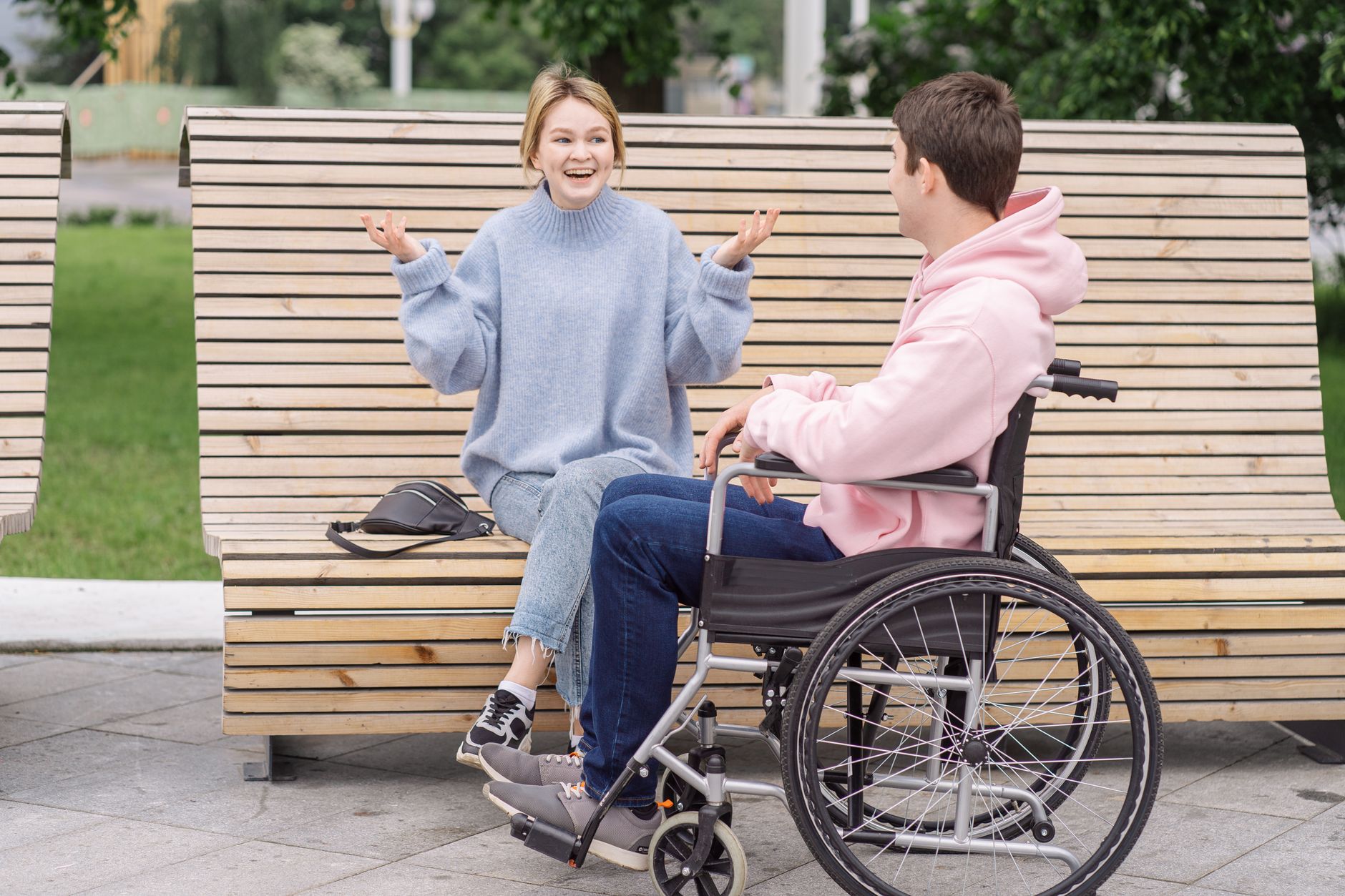 A support worker and a participant sharing a laugh together outdoors